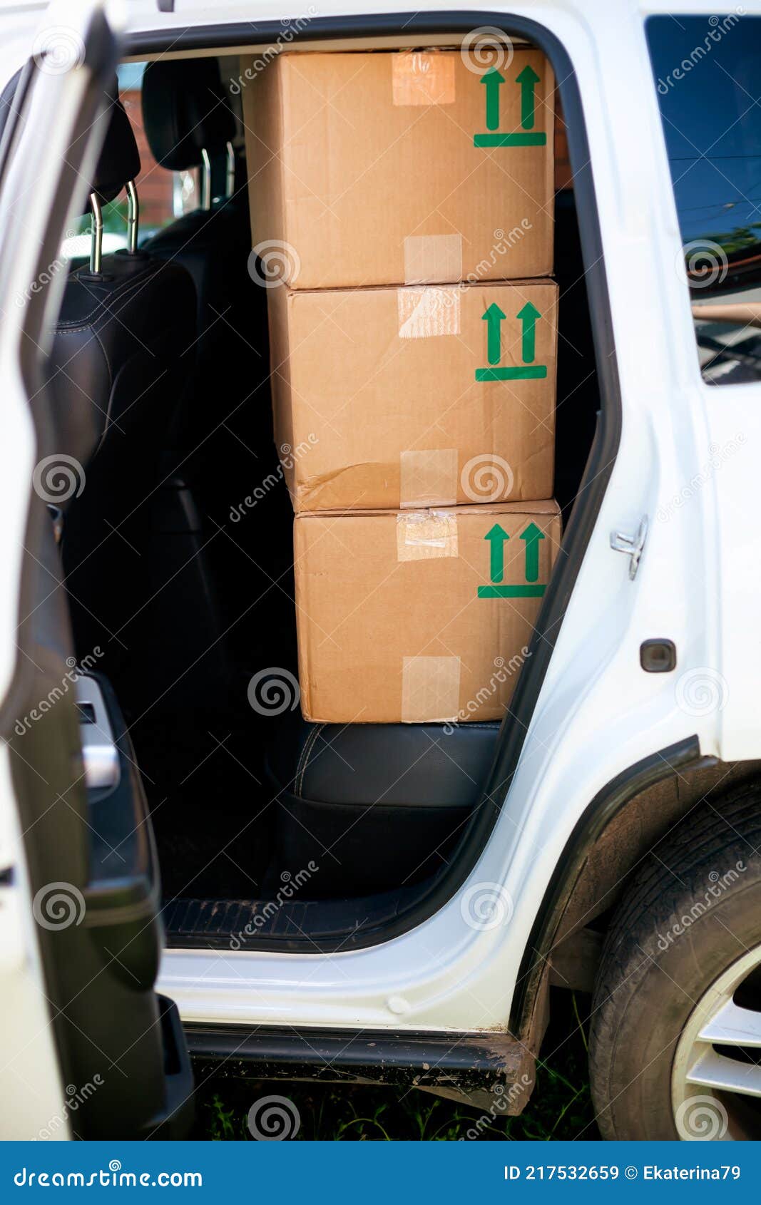Three Cardboard Boxes with Green Sing this Way Up on the Back Seat of the Car Stock Image
