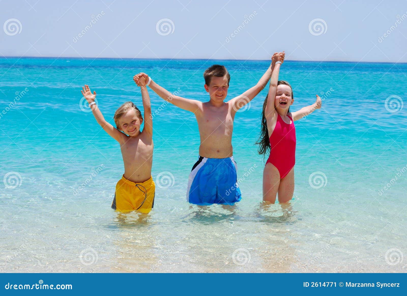 three children wading in ocean