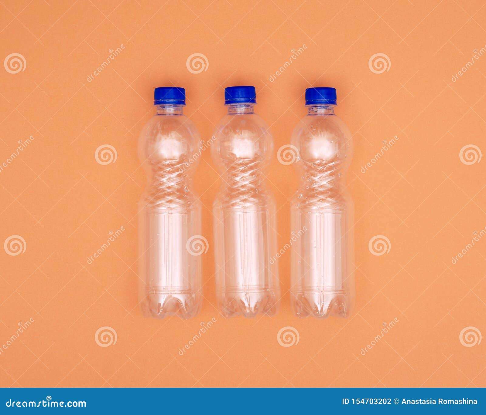 Three Plastic Water Bottles on Orange Background Stock Photo - Image of