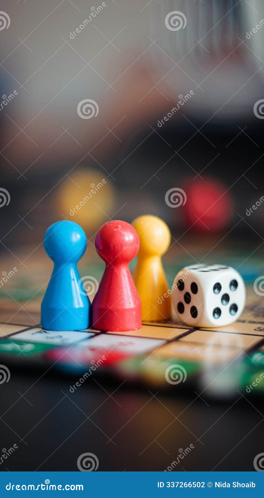 three colorful game pieces and dice on board, focused interaction, blurred background