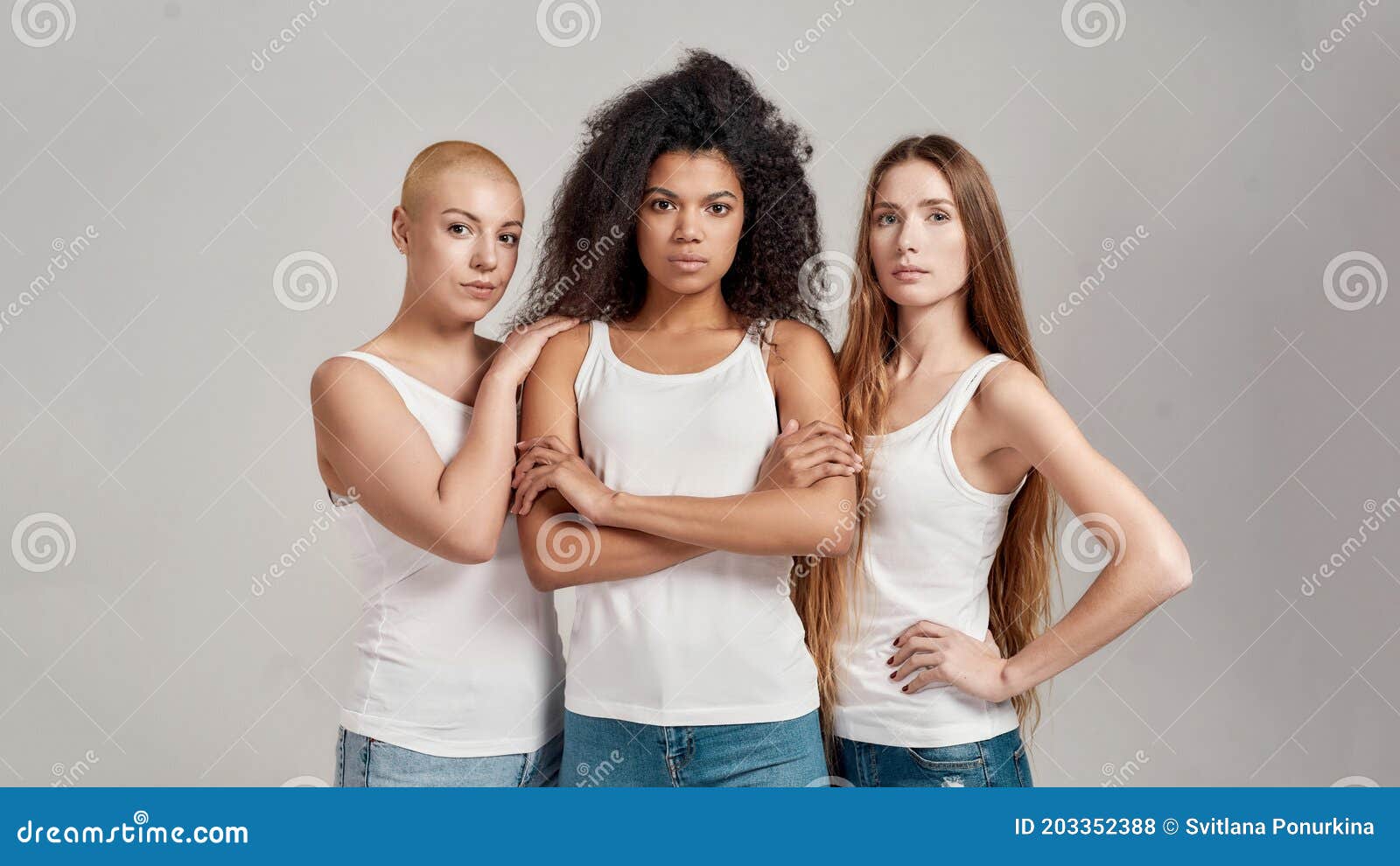 Group portrait of diverse young women wearing clothes in hipster style  looking at each other with smiles and hugging together stock photo