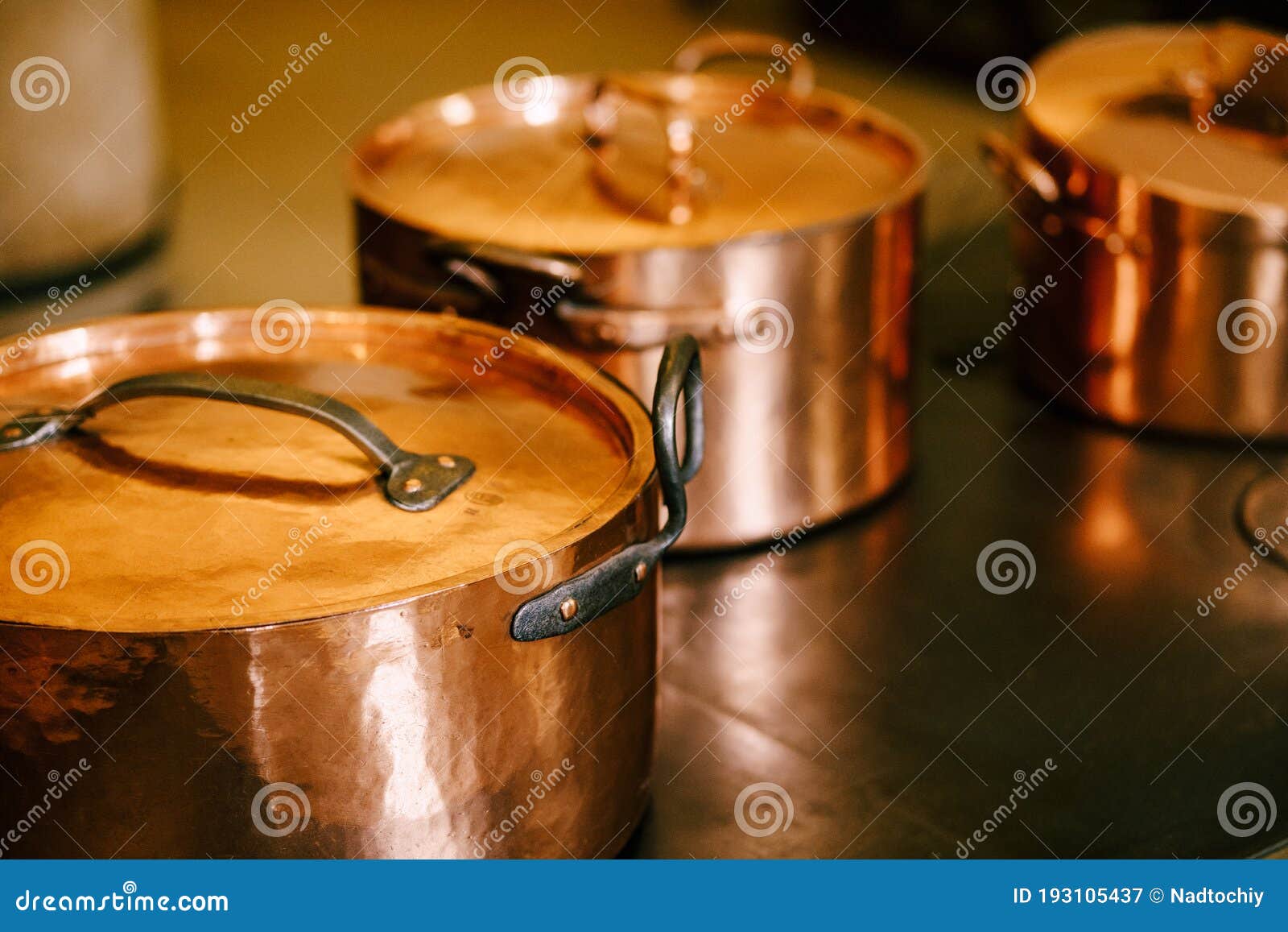 Three Copper Pots with Closed Lids on a Metal Surface. Stock Image