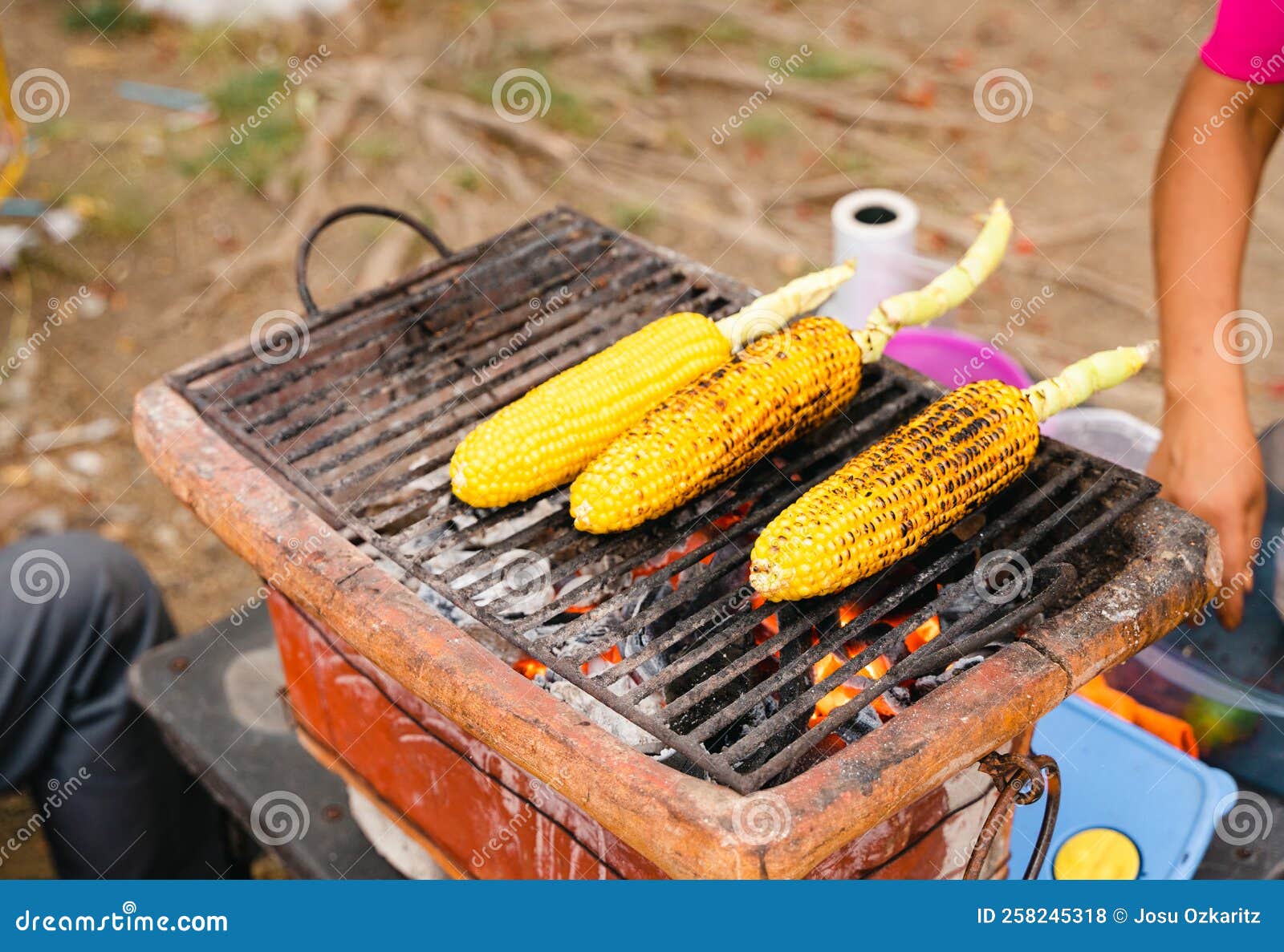 Three Corn On The Cob Grilling At Street Market In Mexico Stock Photo three-corn-on-the-cob-grilling-at-street-market-in-mexico-stock-photo