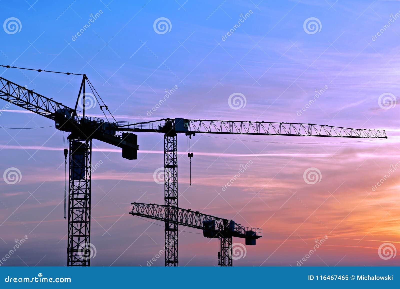 three cranes on the construction site of a new housing esta