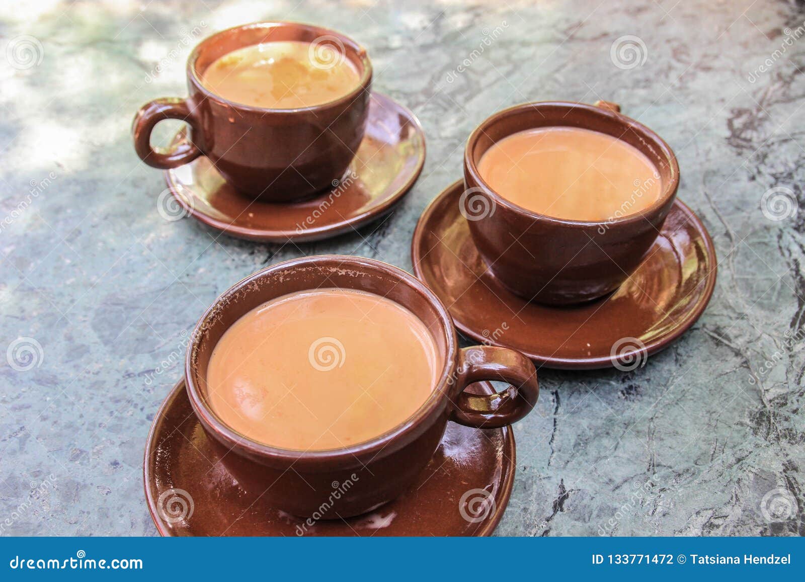 Three Cups of Traditional Nepalese Tea with Milk and Spices in Brown