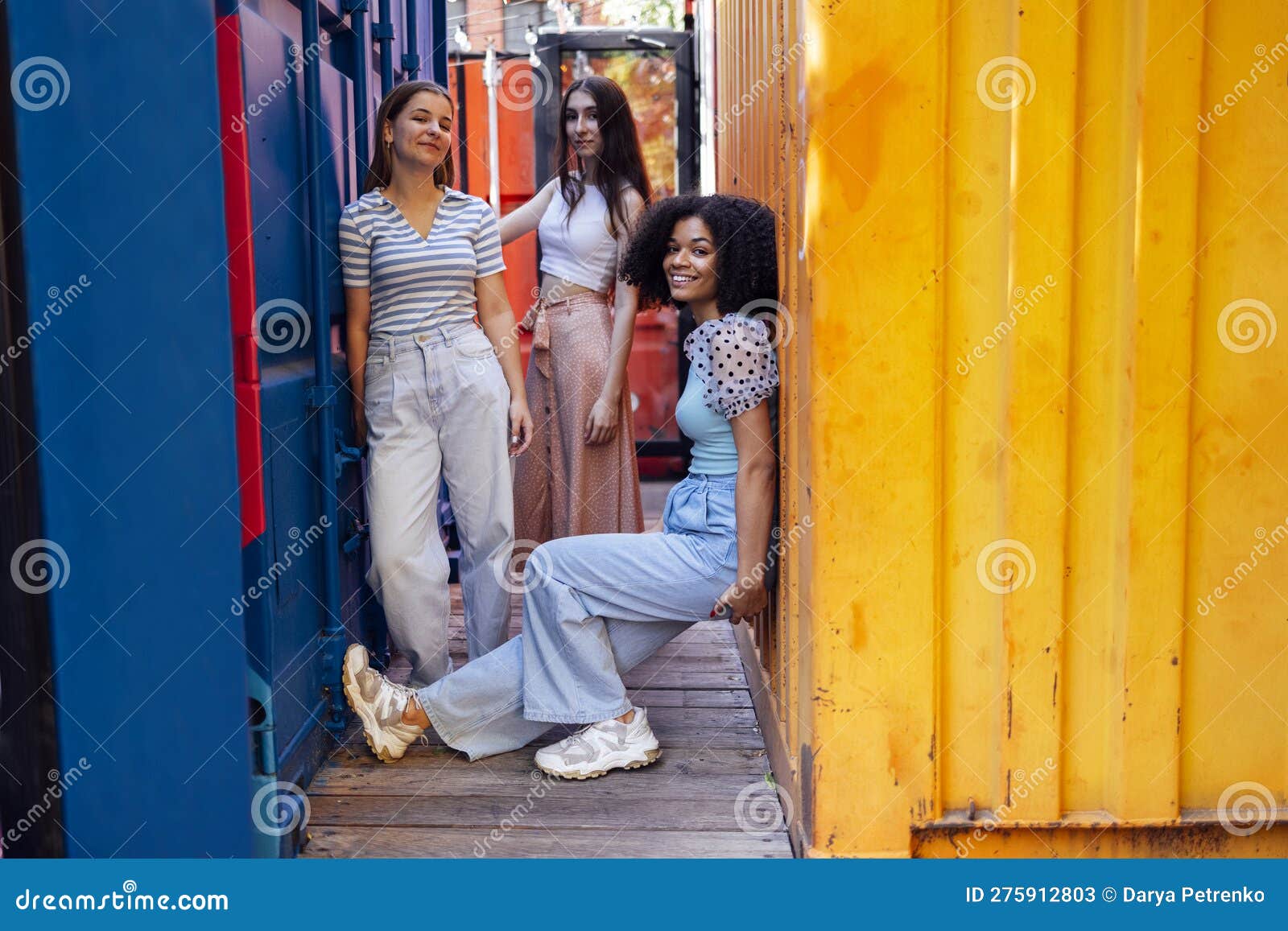 Three Funny Street Style Hipster Girls Posing At White Brick Wall
