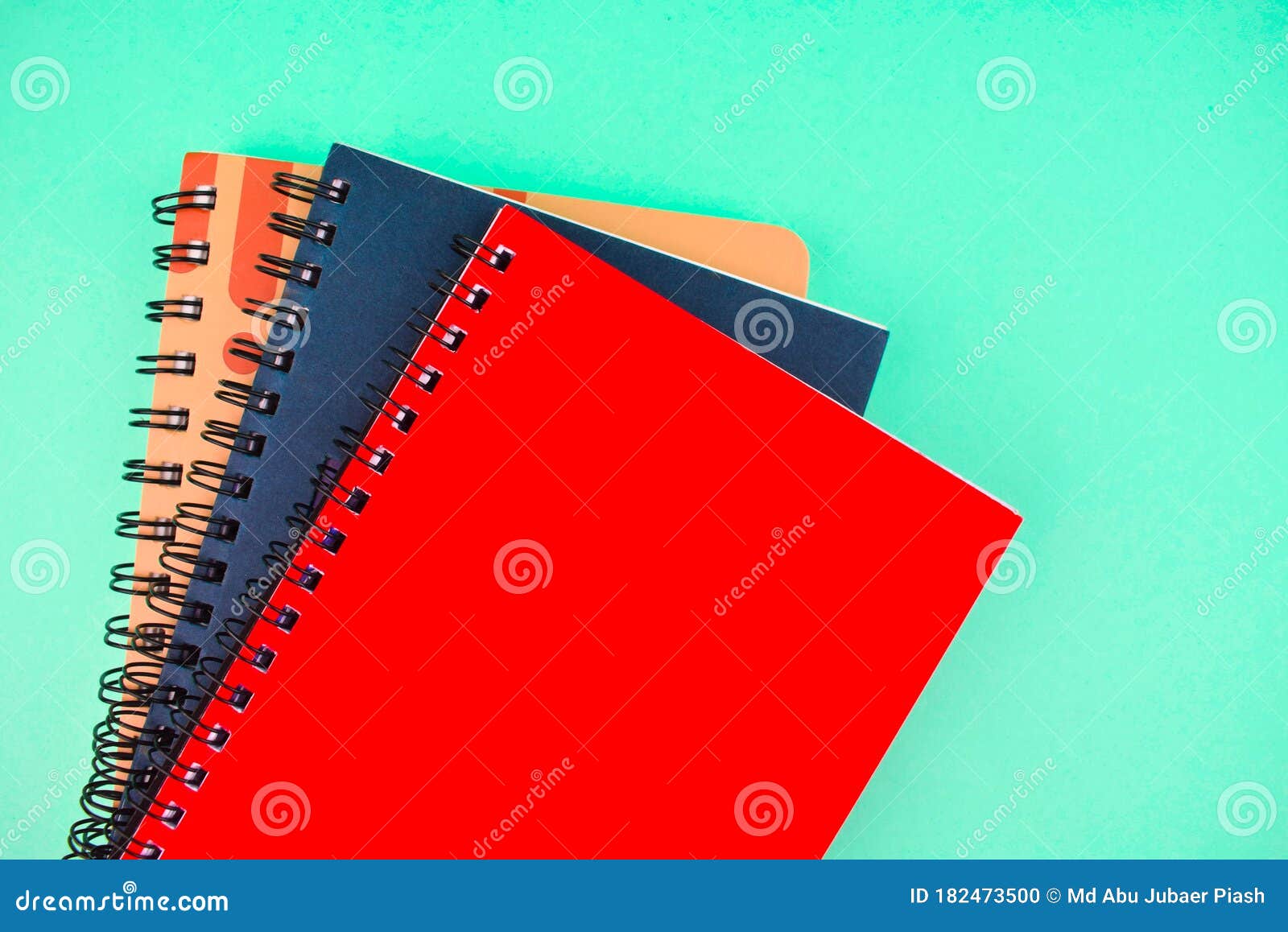 Three Different Colored Note Paper Diary Placed on Top of Each Other on a Blue Background Stock