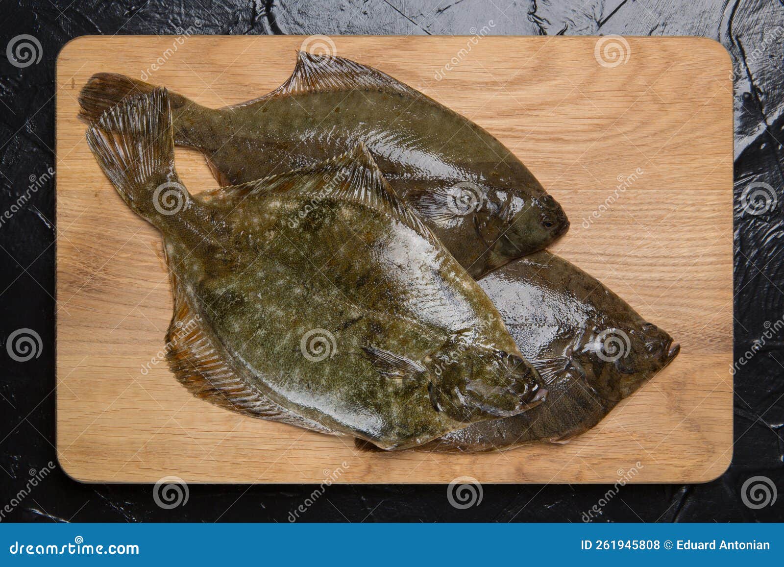 Three Fresh Raw Flounders on an Oak Cutting Board, Sea Fish Stock Photo