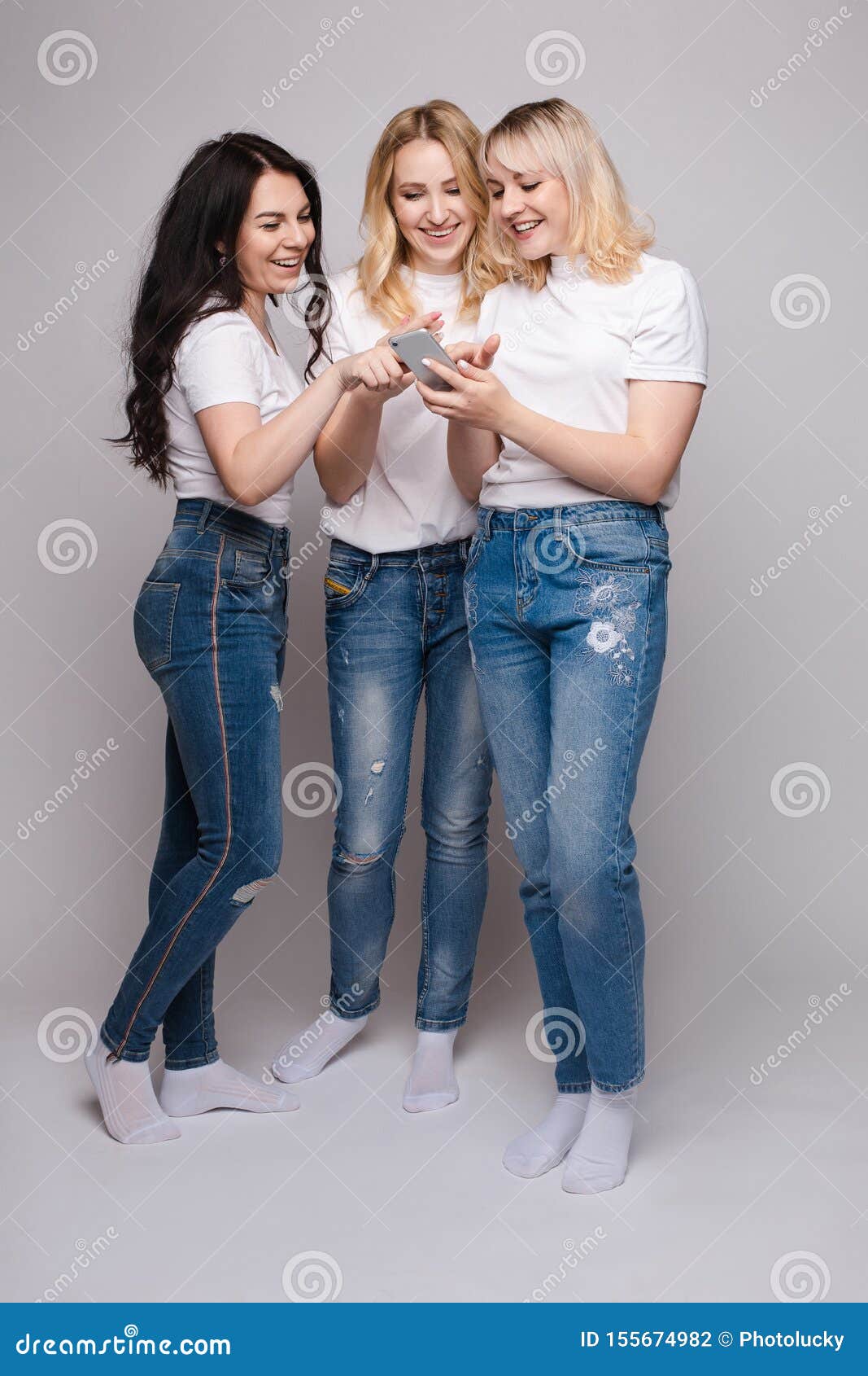 Three Friends in White Shirt and Jeans Looking at Phone Stock Photo - Image  of cheerful, beautiful: 155674982
