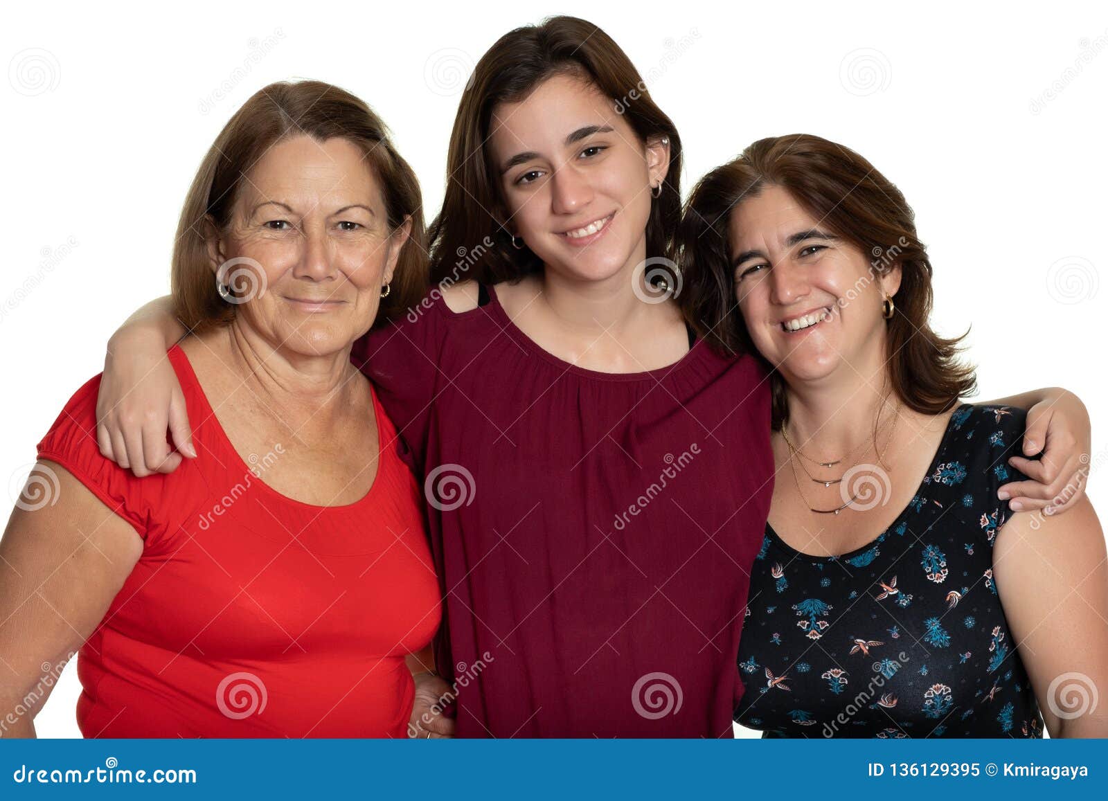 three generations of latin women smiling and hugging - on a white background