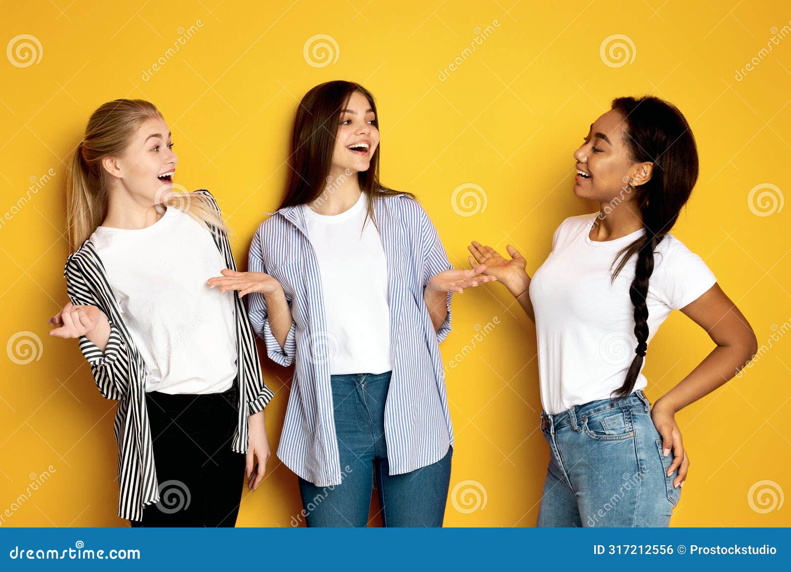 three girls engaging in lively conversation against vibrant yellow background