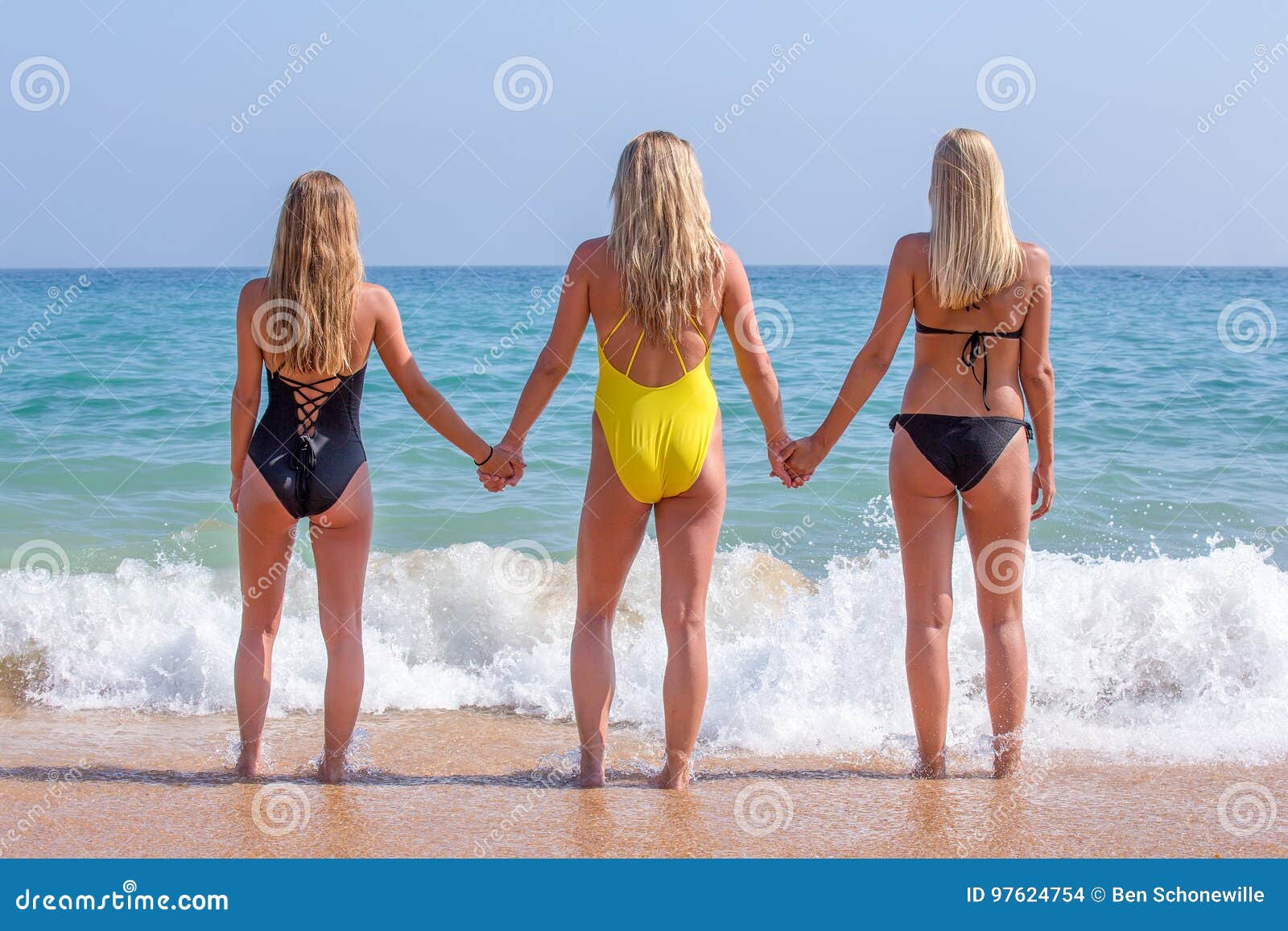 Beautiful Young Women Bodysuits Holding Hands Sandy Beach Looking
