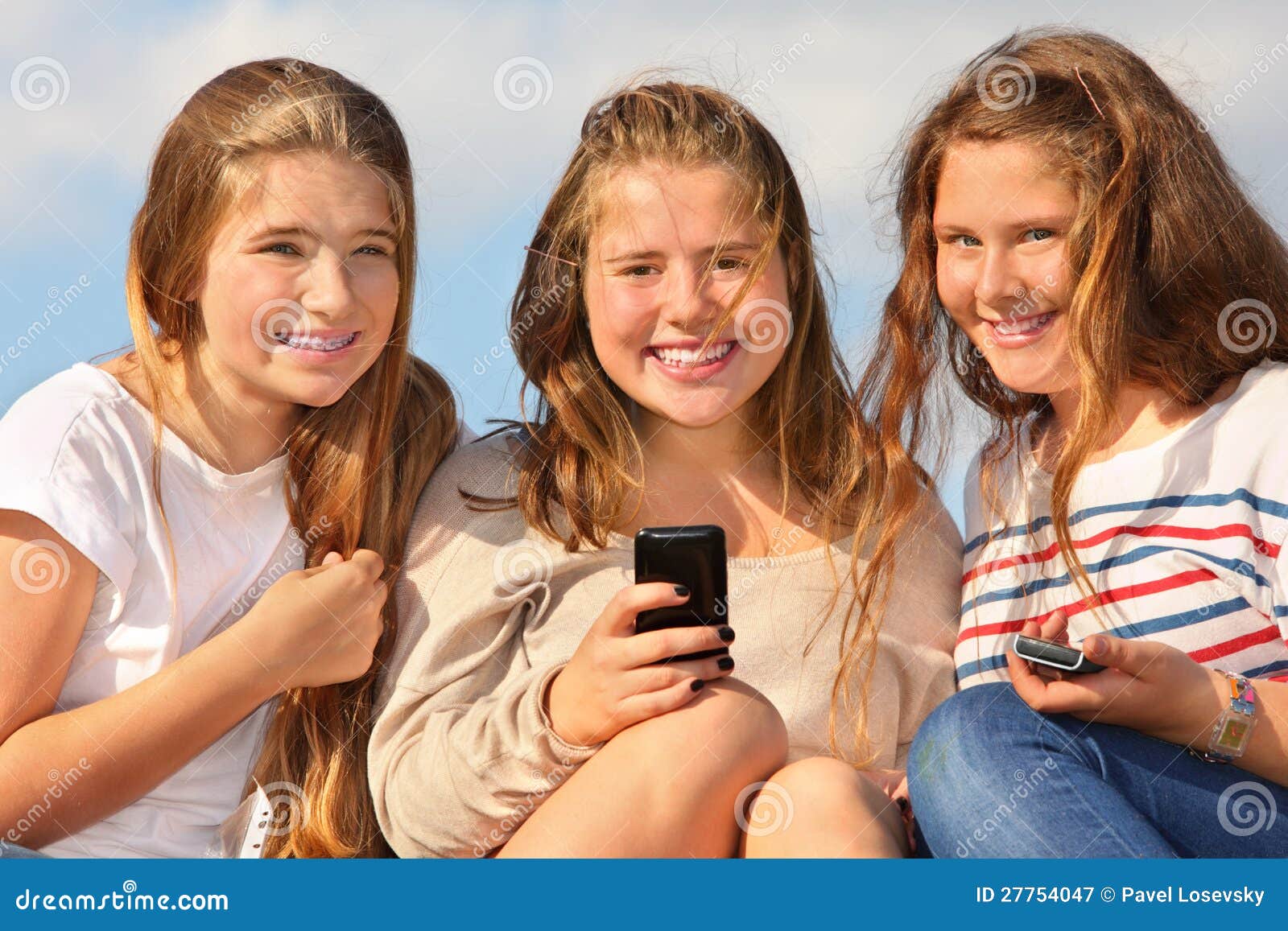 Three Girls Sit with Mobile Phones and Smile Stock Image - Image of ...