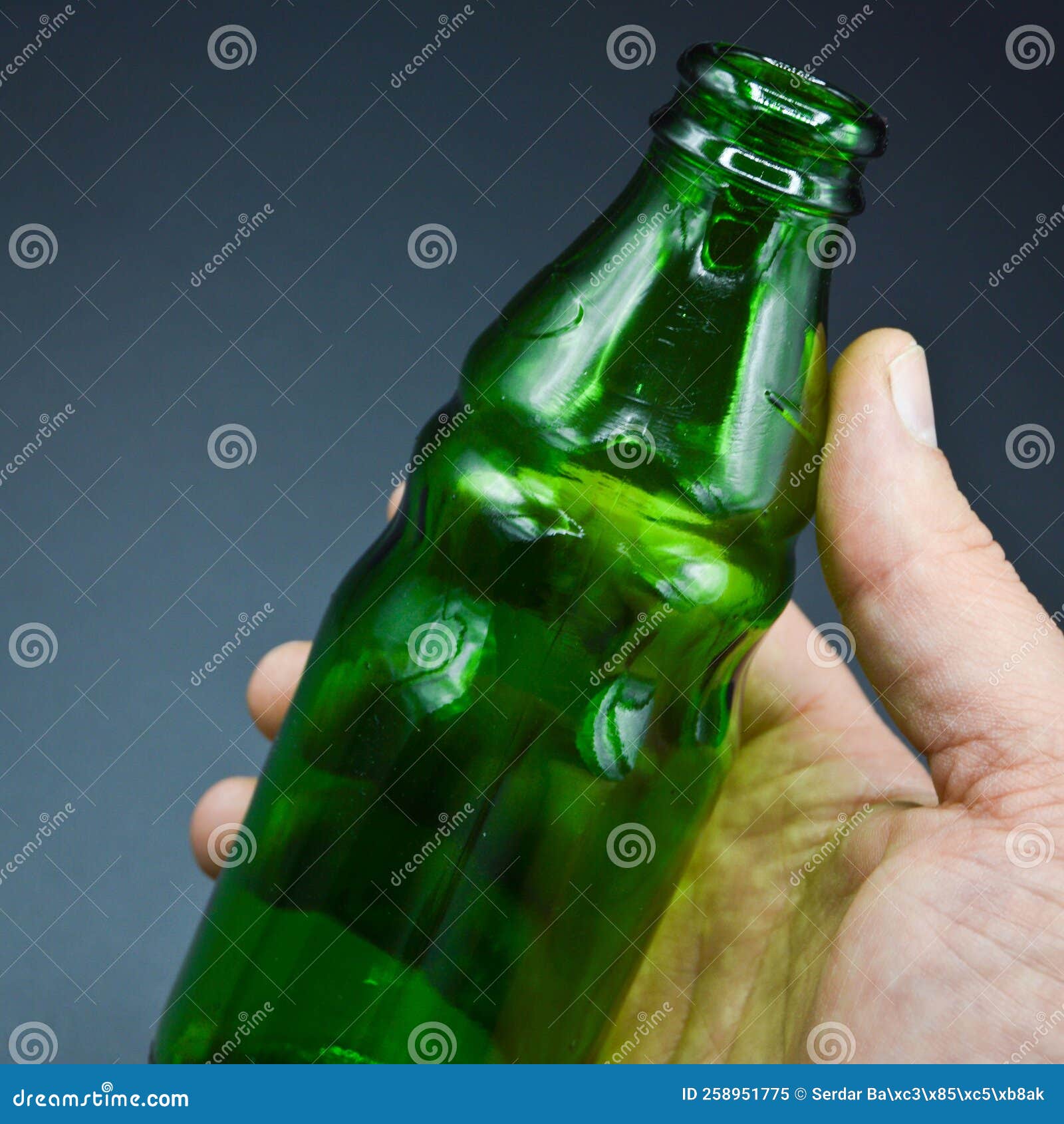 Three Green Empty Glass Soda Bottles and Hand, Isolated on Gray