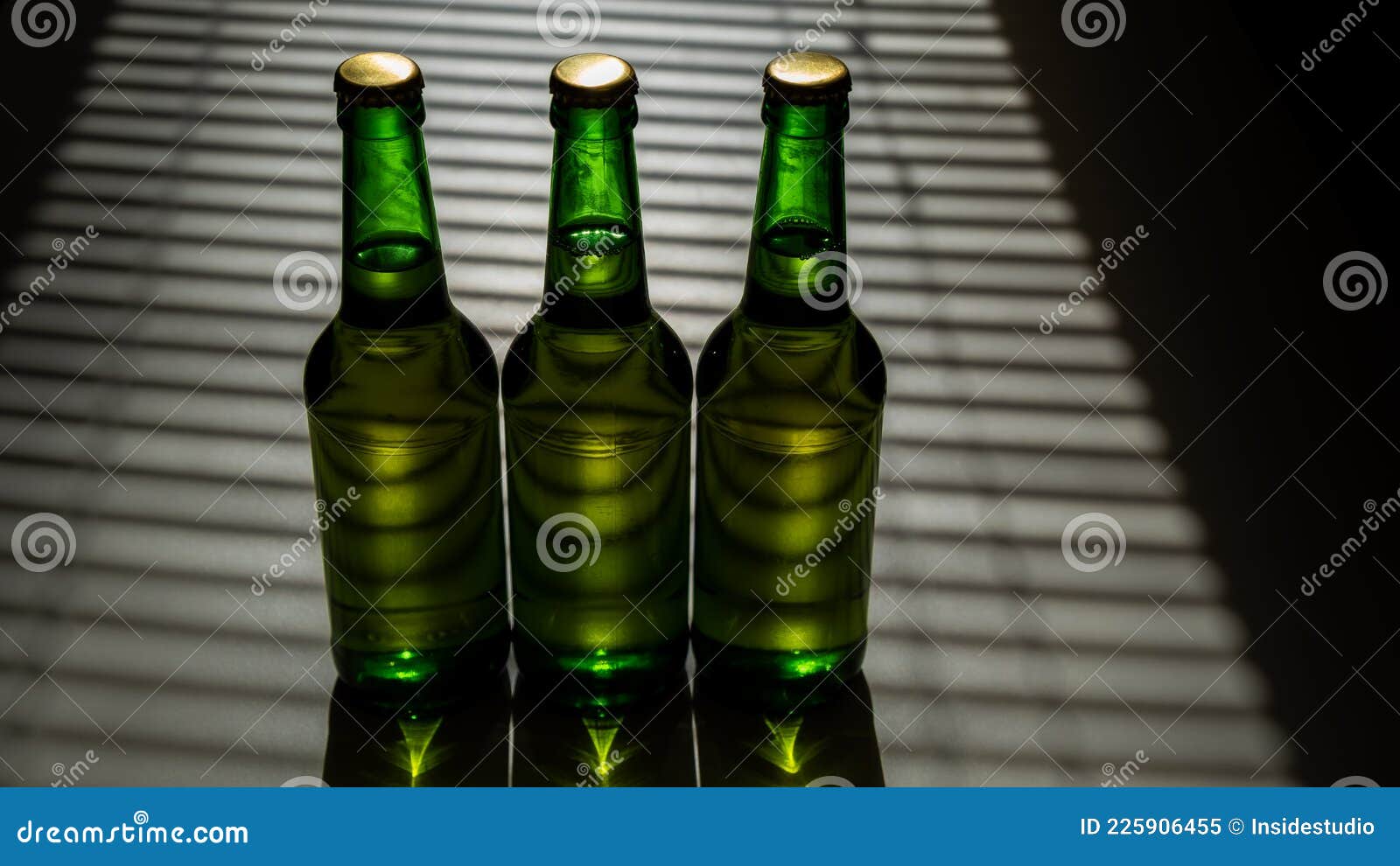 Three Green Glass Beer Bottles in the Shade of the Blinds. Stock Image