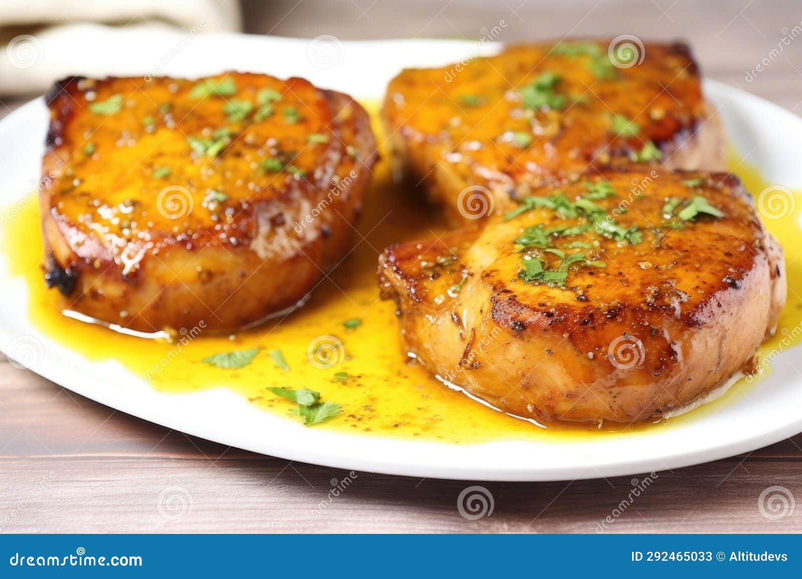 Three Honey Mustard Pork Chops on a White Plate with Garnish Stock