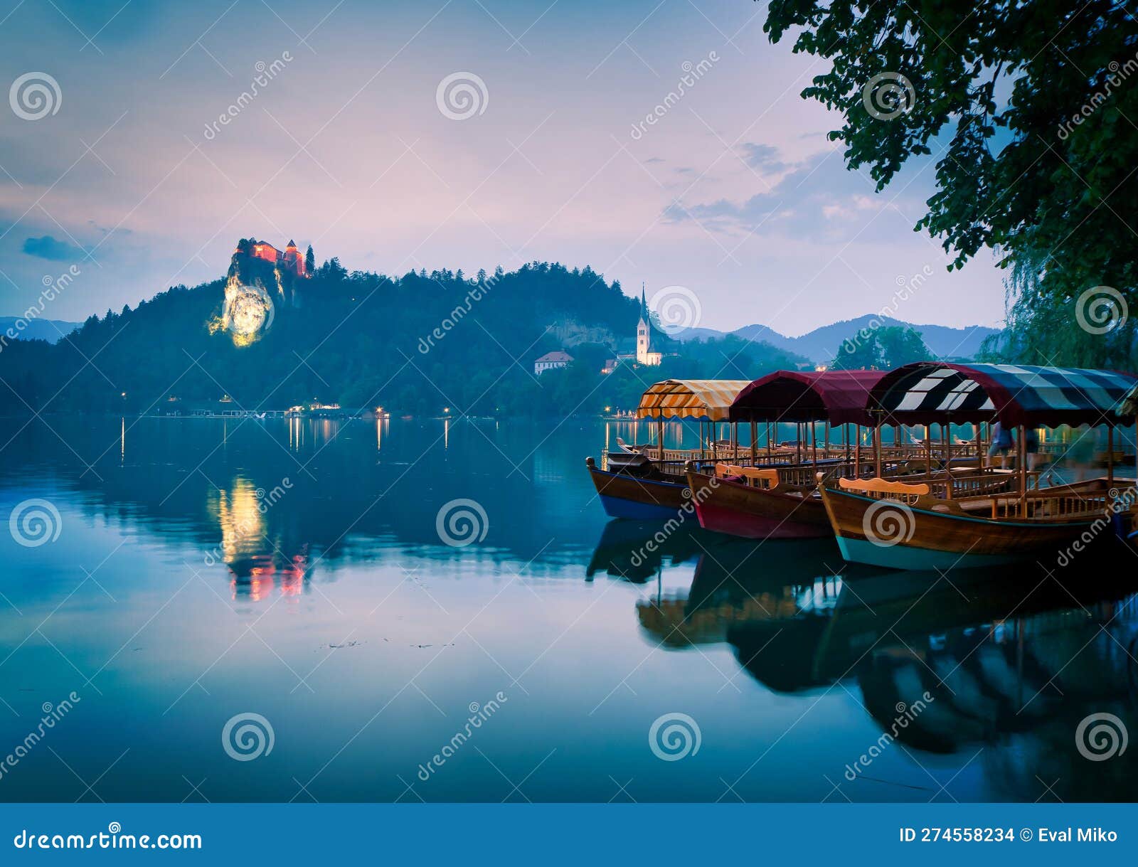 three lake tour boats standing on famous bled lake with castle on the background and island church. peaceful relaxing holiday