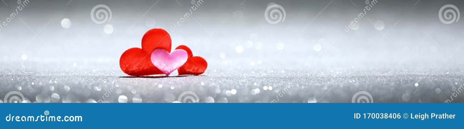 three little red and pink hearts on sparkling silver background. for love, romance, or valentine`s day