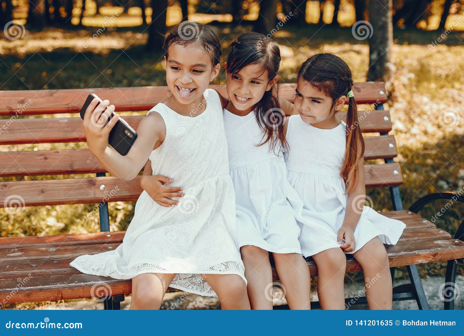 Three Little Sisters Sitting in a Summer Park Stock Image - Image of ...