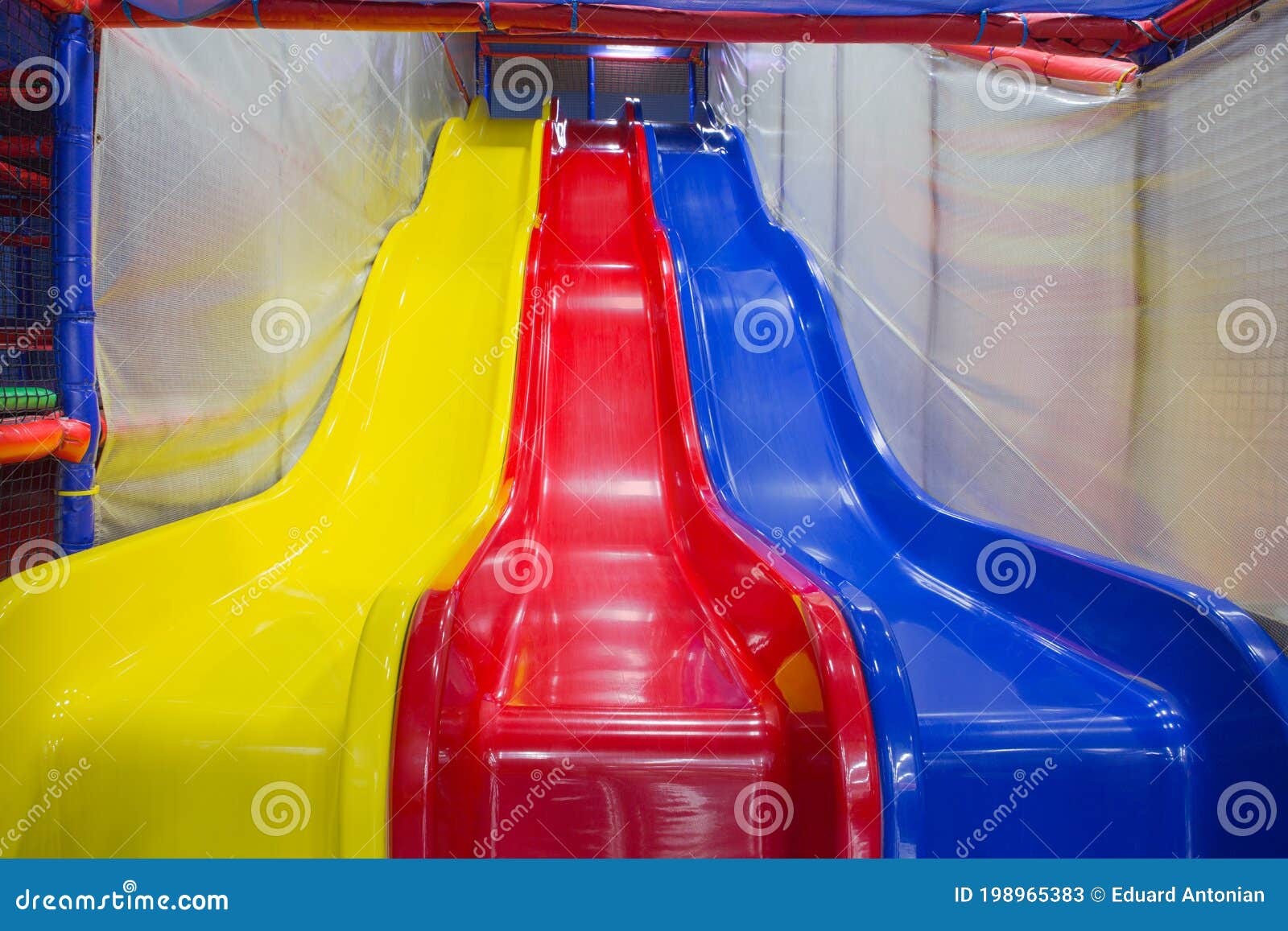 Three Multicolored Plastic Slides in the Children`s Play Complex