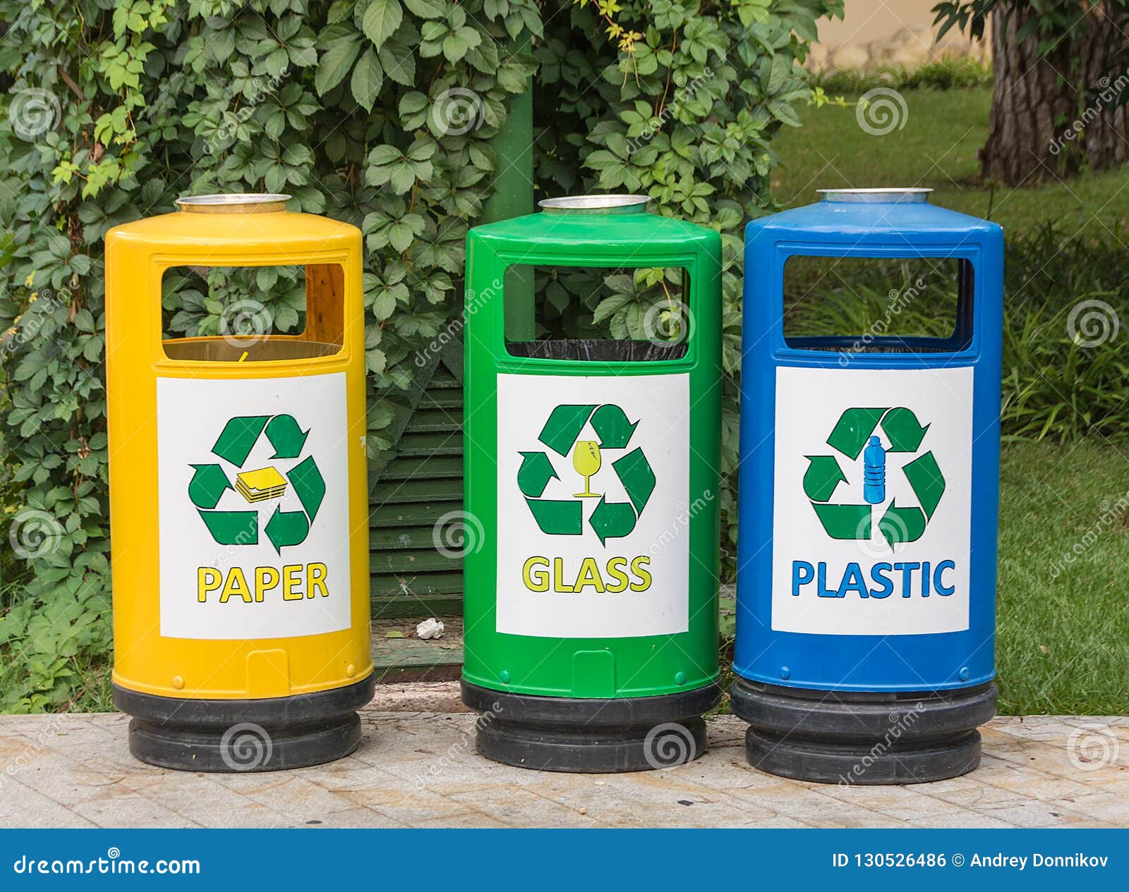 three multicolored recycle bins for waste with icons for the convenience of sorting junk waste in the garden