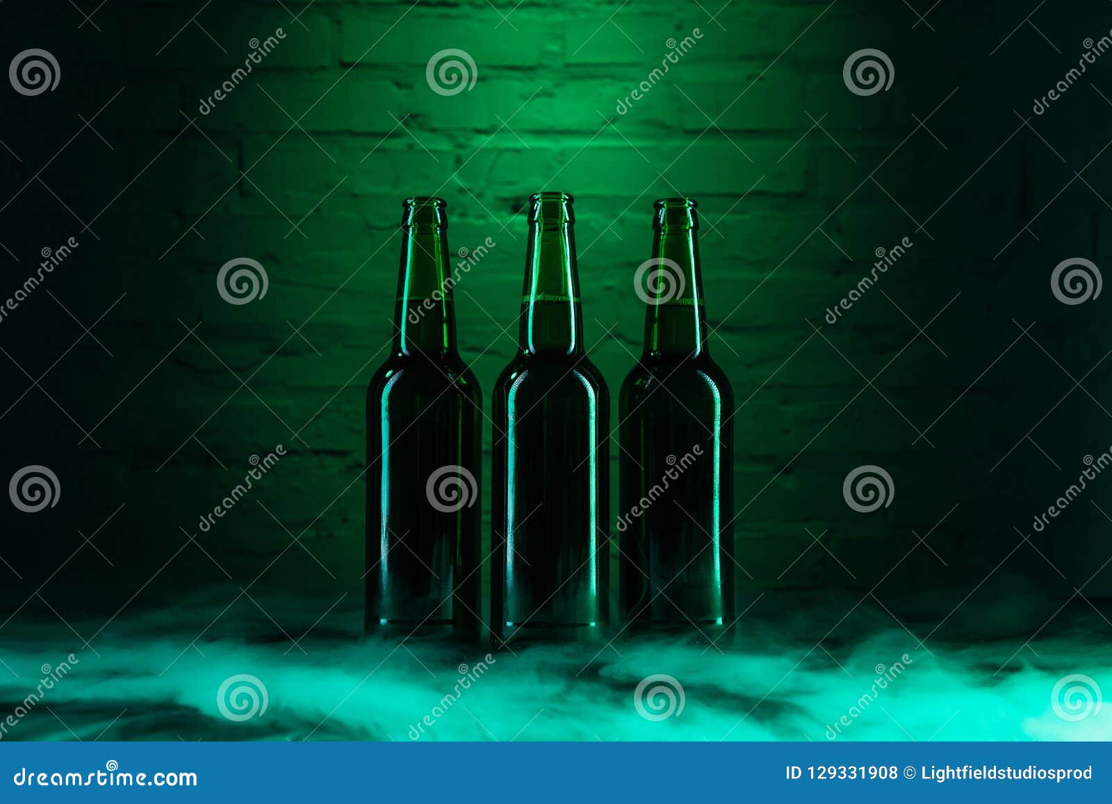 three open green beer bottles and smoke in green