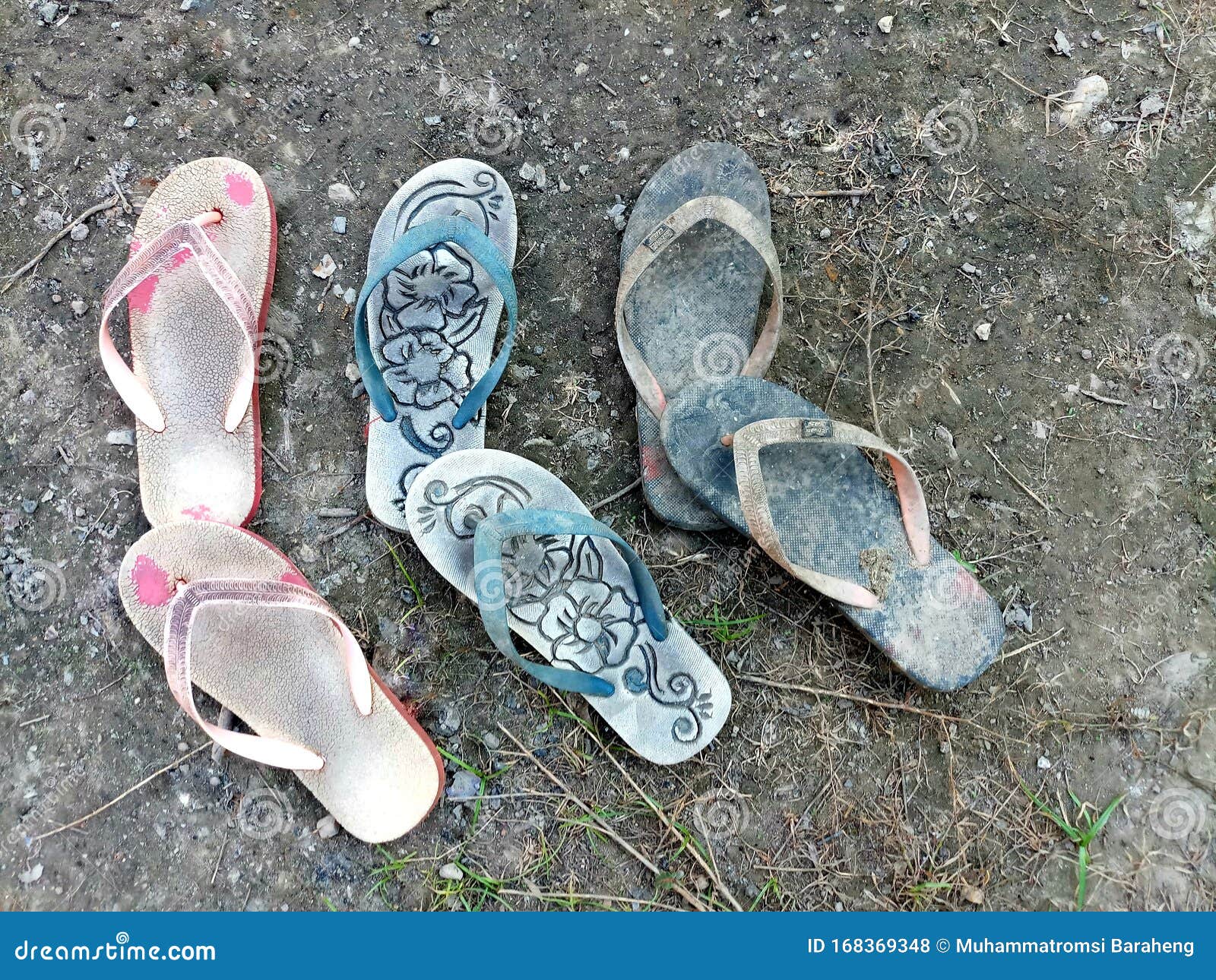 Three Pairs of Old Slippers on the Ground with Dry Grass and a Little ...