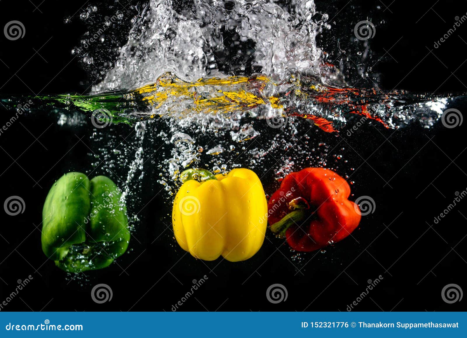 Three Paprika Splash in Water on Black Background, Capsicum Annuum
