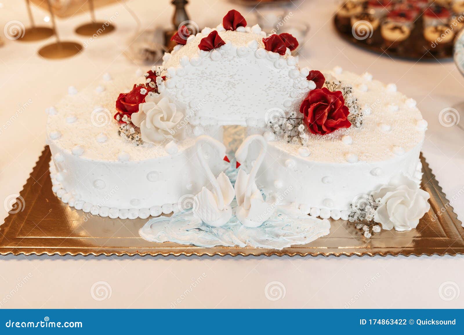 White Wedding Cake with Two Sugary Swans and Red Roses Stock Photo ...