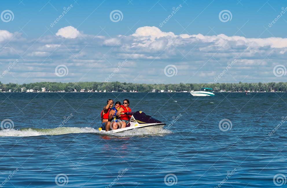 Three people on a jet ski editorial photo. Image of lake 75663416