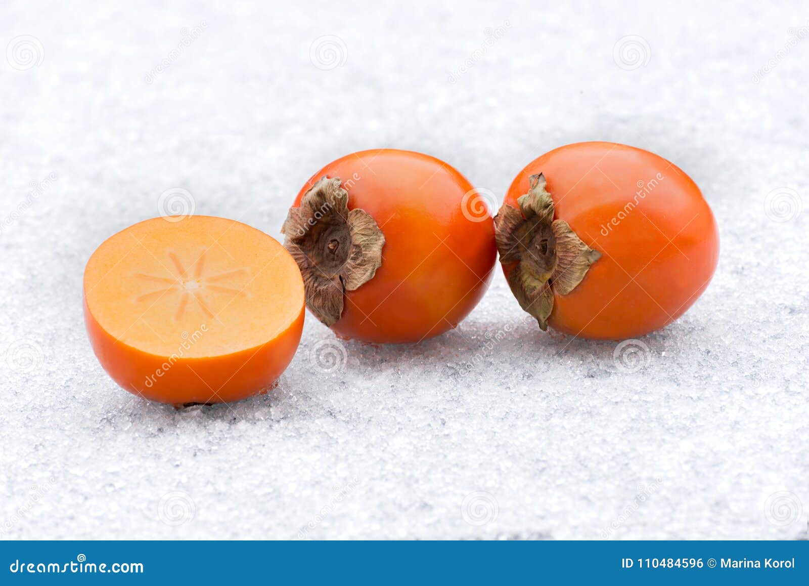 Three Persimmons On Ice. Half Of Fruit And Two Whole Persimmons. Stock ...