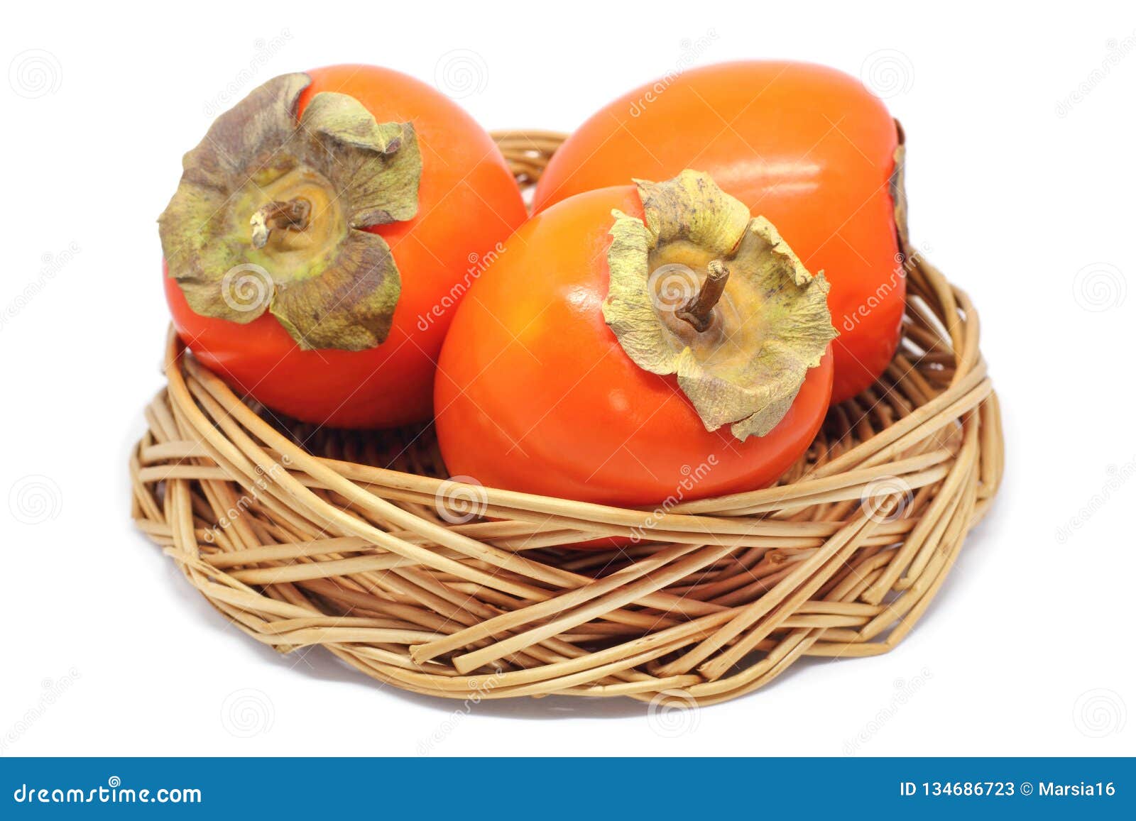 three persimmons in a wicker bowl  on white