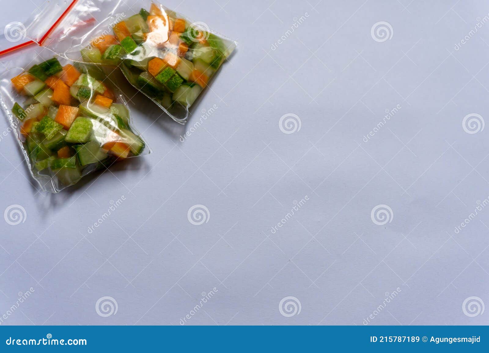Three Plastic Bags of Pickles Made from Cucumber and Carrot on a White