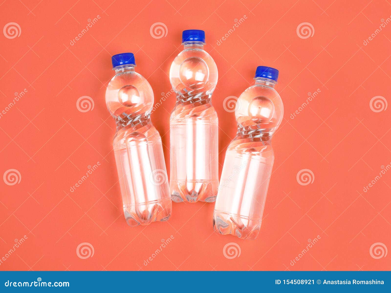 Three Plastic Water Bottles On Orange Background Stock Image - Image of