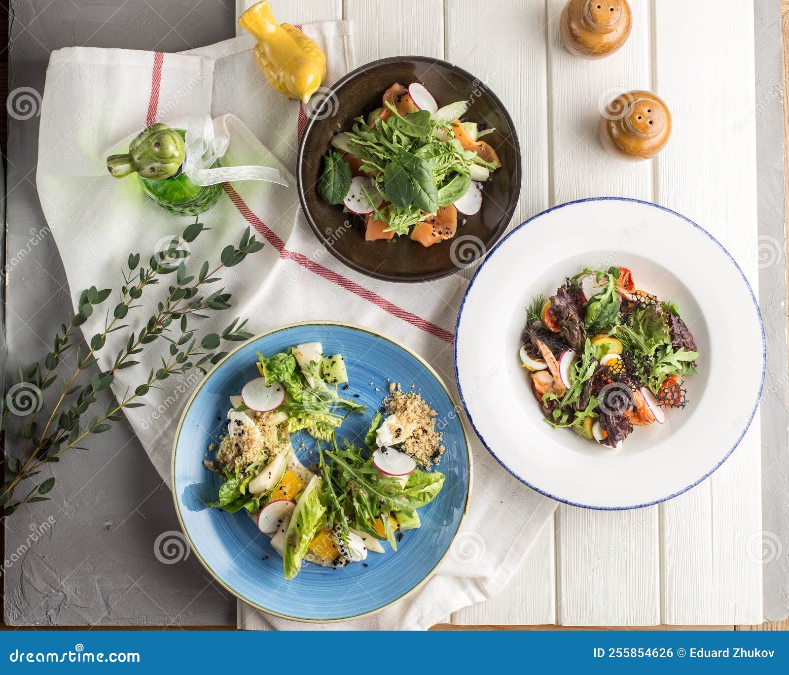 Three Plates Set of Green Healthy Salad on White Table Restaurant Menu