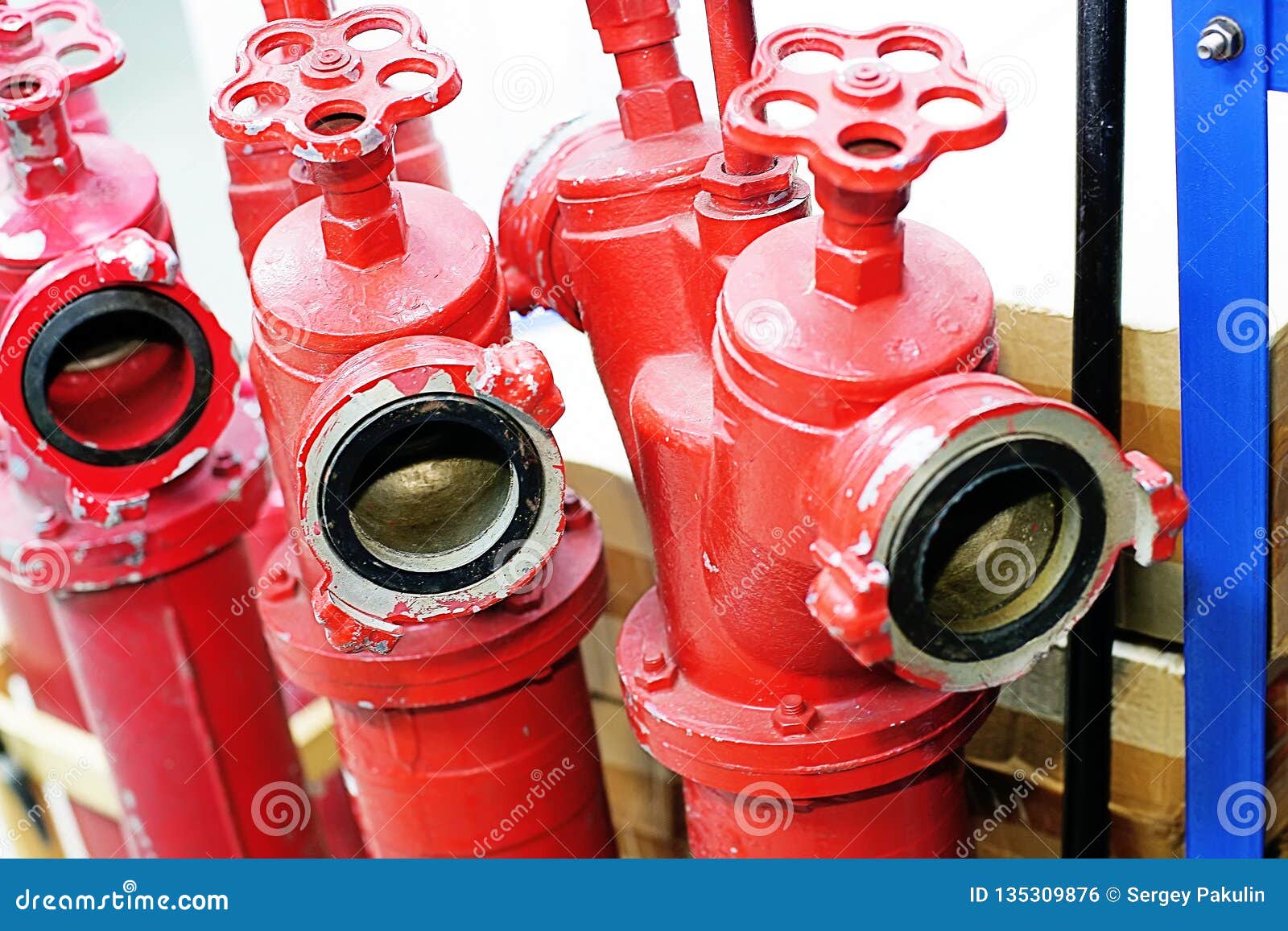 Three Red Fire Hydrants with Valves are in the Warehouse Stock Photo
