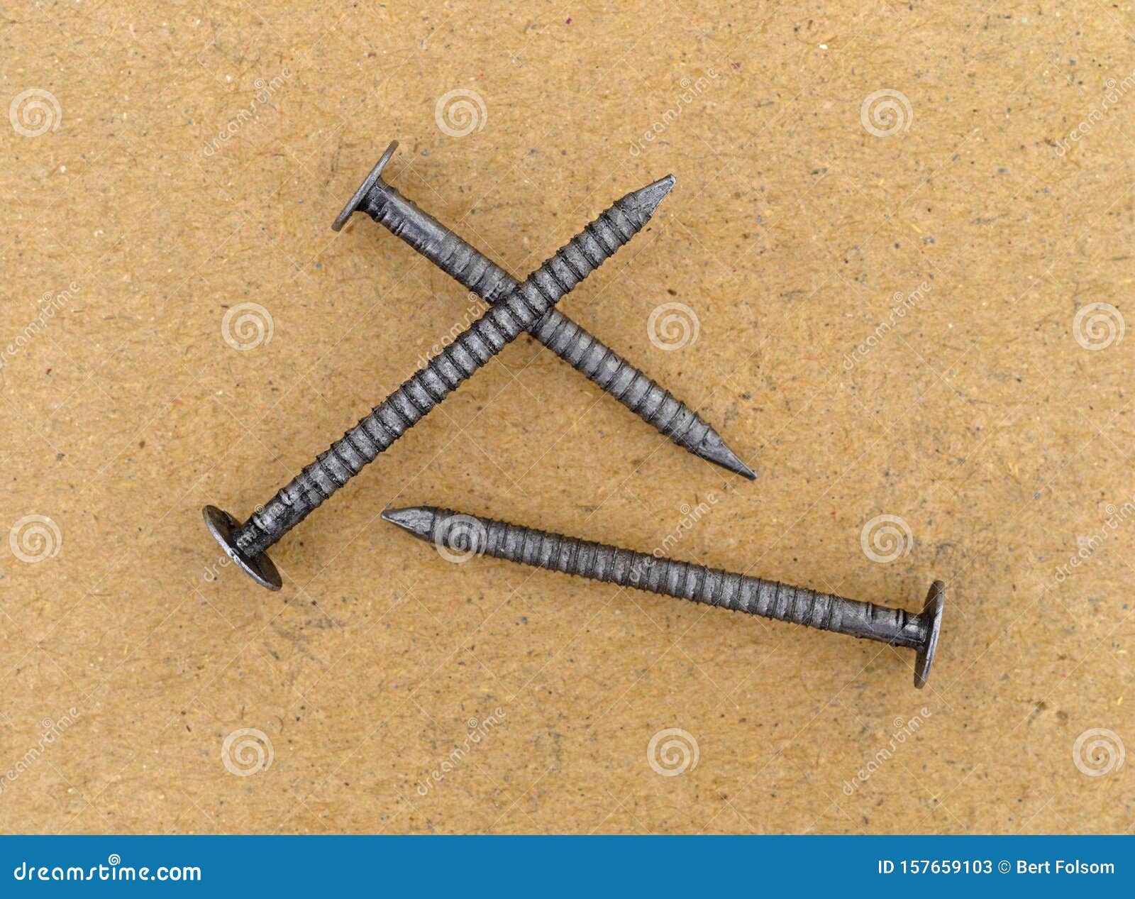Three Ring Shank Underlayment Nails on a Cardboard Surface Stock Image