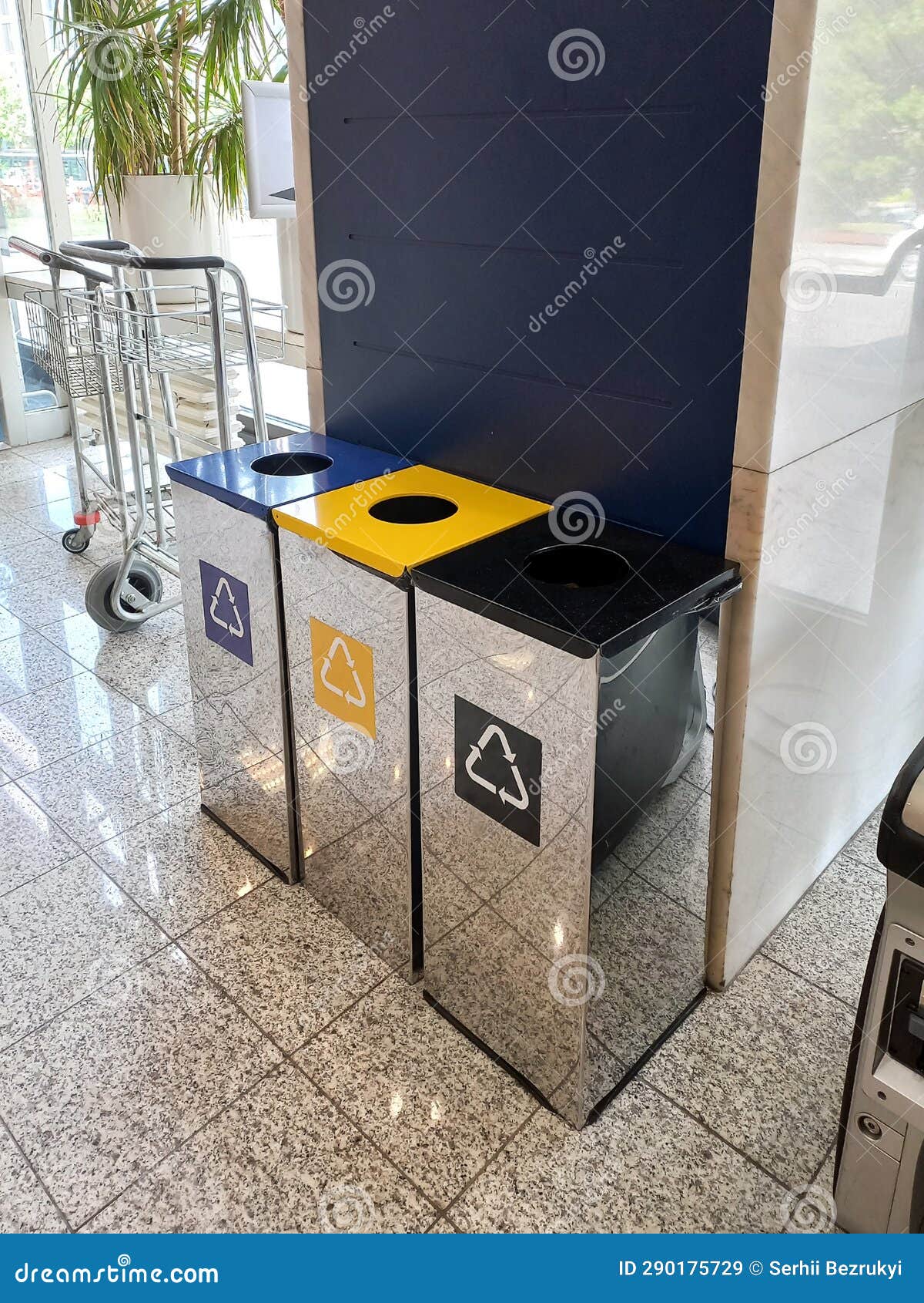 Three Shiny Metal Bins for Separate Collection of Garbage on the