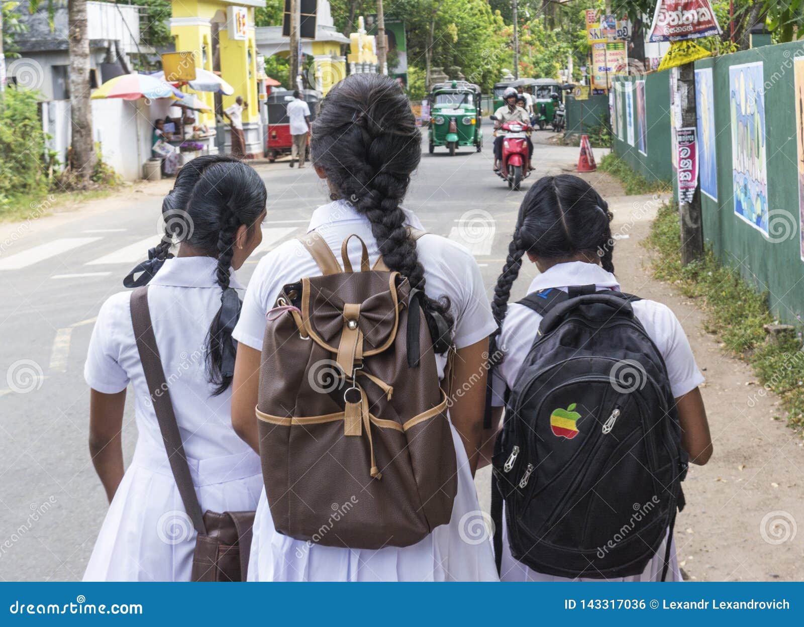 Sri Lankan schoolgirls share a light moment as they walk 