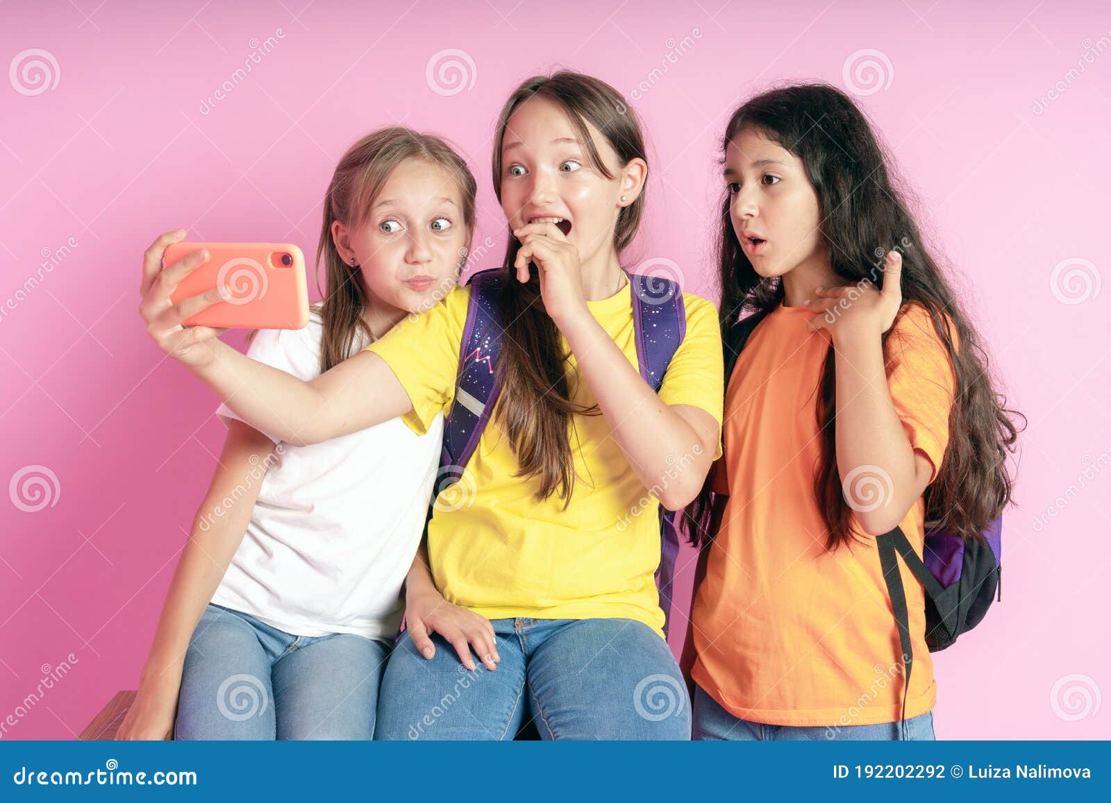 Three Teen Girls Smiling and Shoots a Video on a Pink Background ...