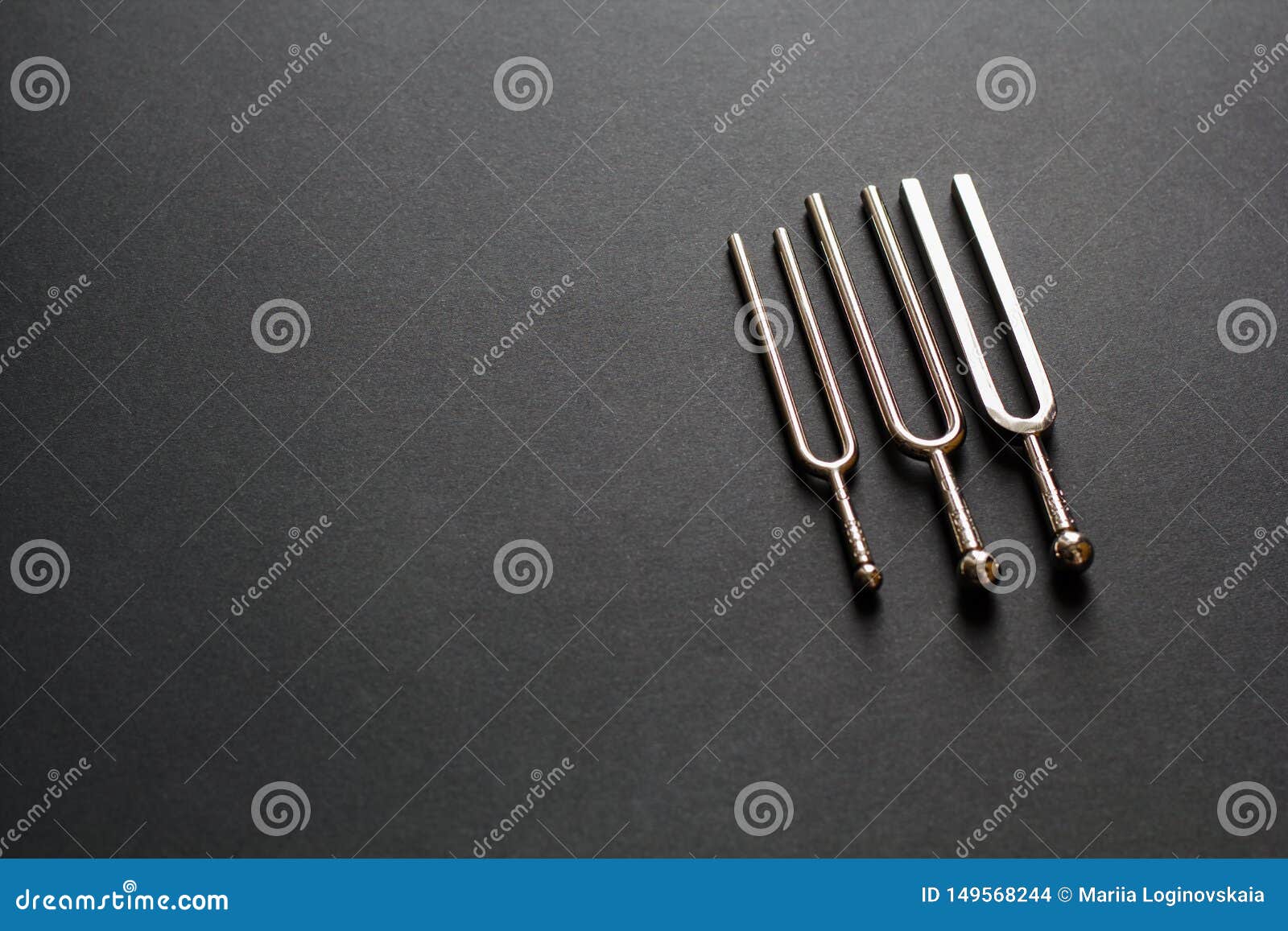 three tuning forks on a black background