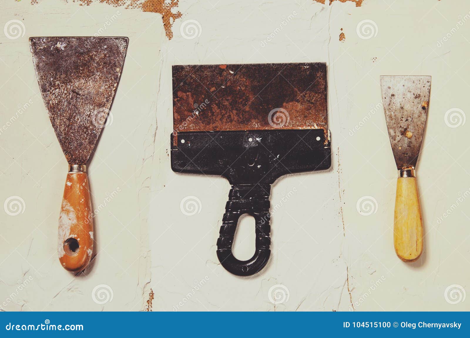 Three Vintage Putty Knives on the Background of Putty Stock Photo
