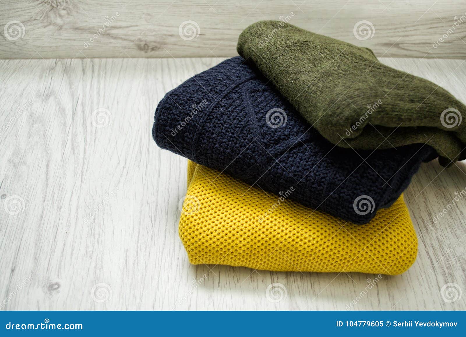 Three Warm Colour Sweaters on a Wooden Background. Fashionable C Stock ...