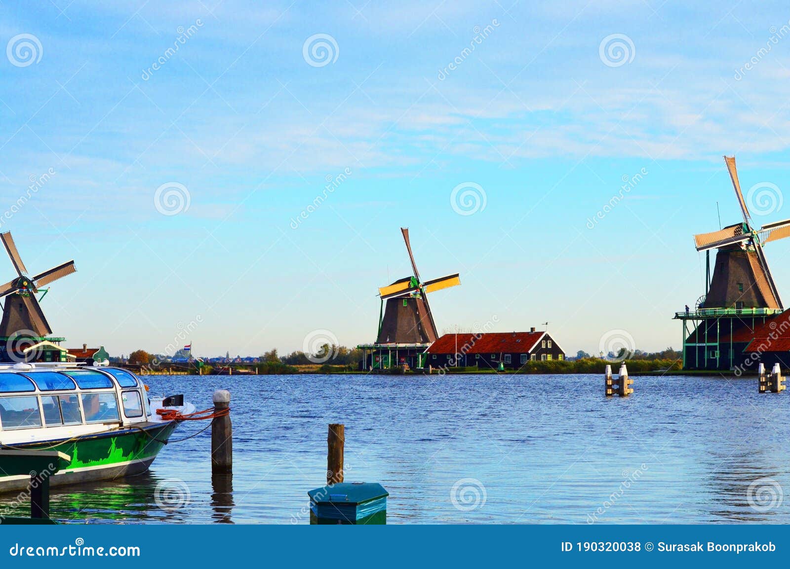 three windmills by the river in the netherlands