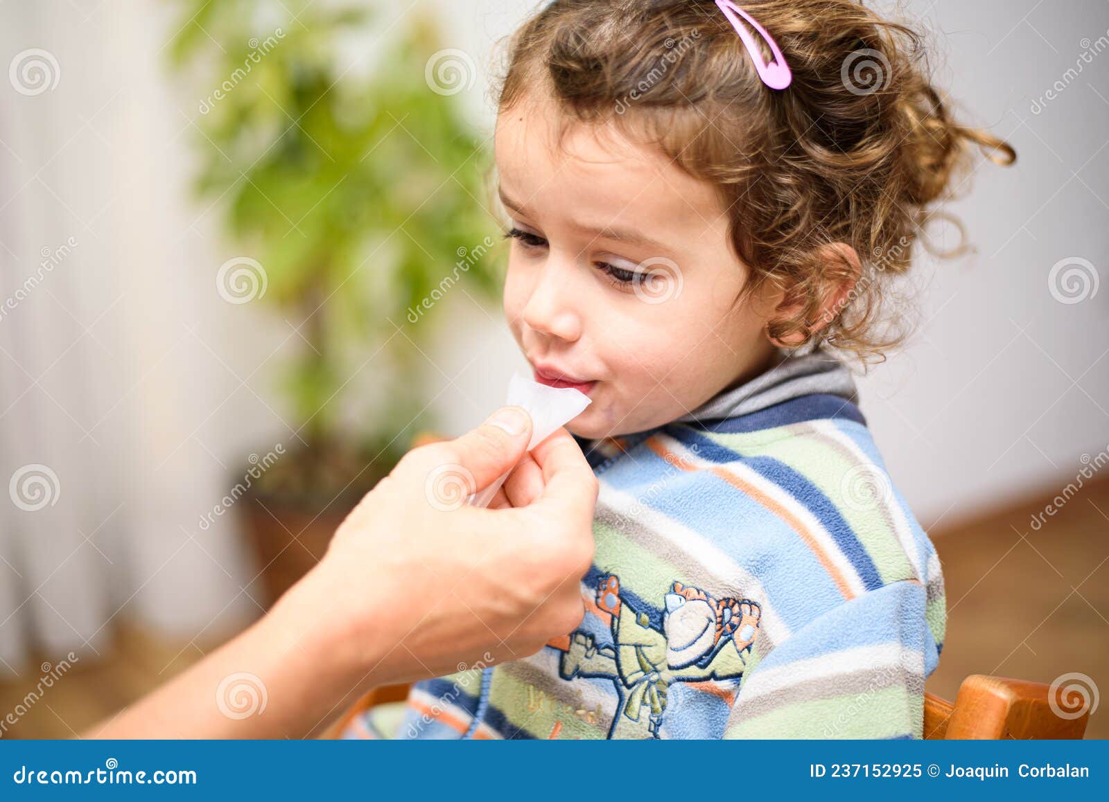 a three-year-old girl spits into a saliva test tube for covid19 antigens