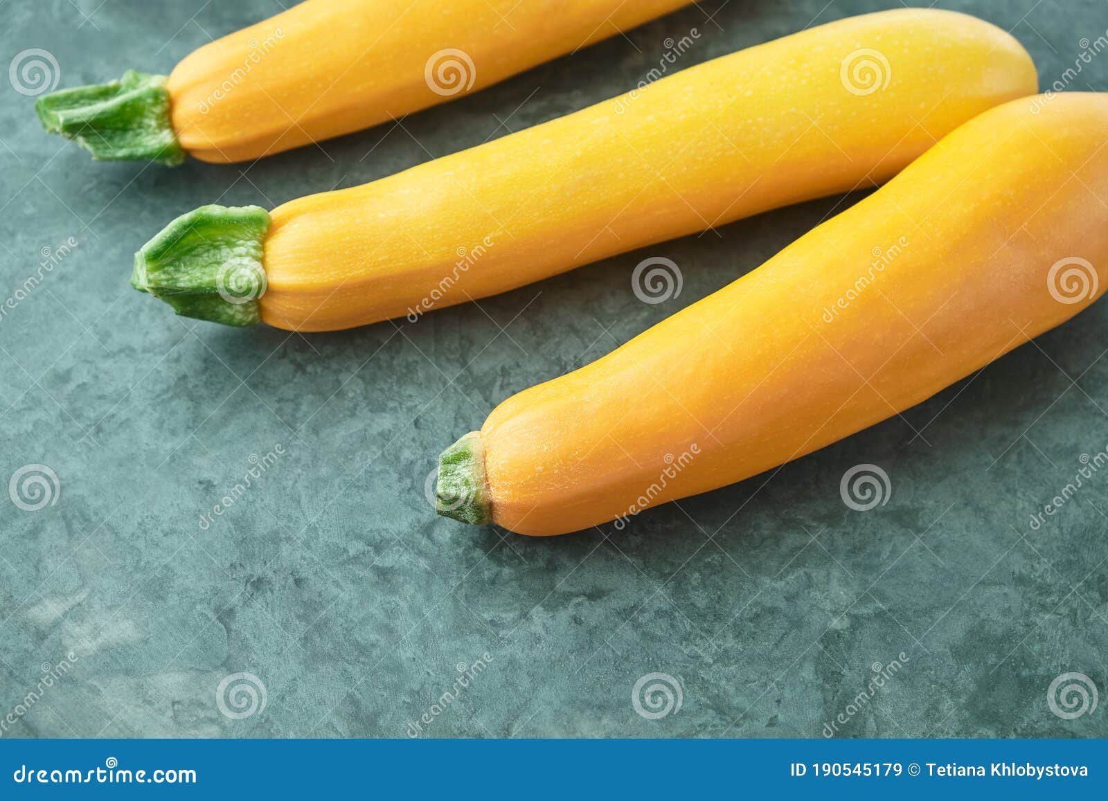 Three Yellow Zucchini on Kitchen Table. Whole Raw Courgettes Stock