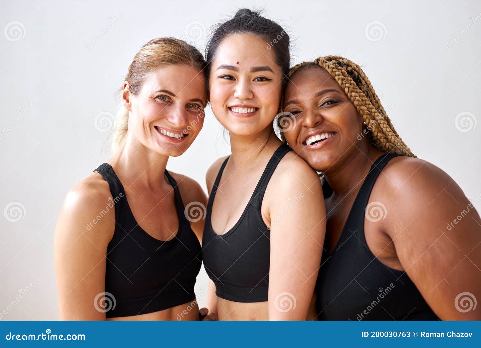 three young multi ethnic female models of different race, hair colour and body size posing at camera