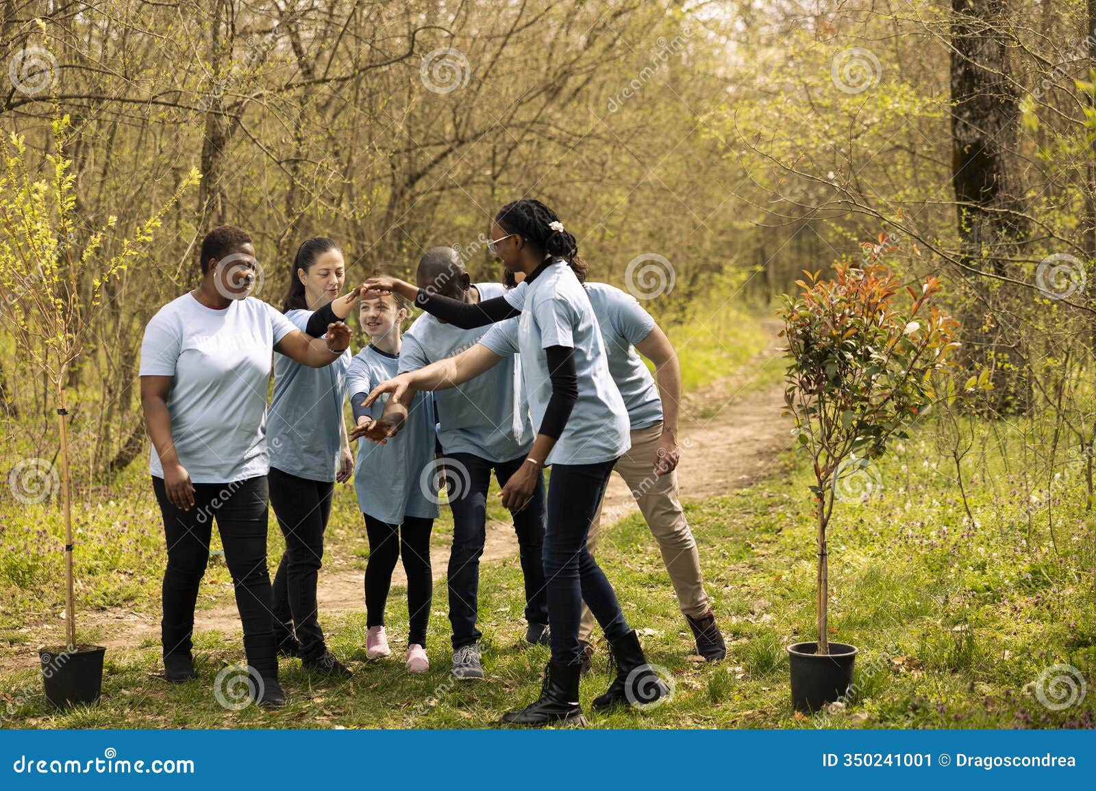 thrilled group of helpers join hands in satisfaction to fix natural areas