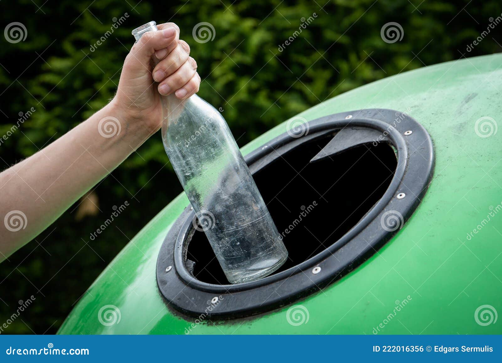 Throwing Empty Glass Bottle into Green Recycle Bin Garbage Container