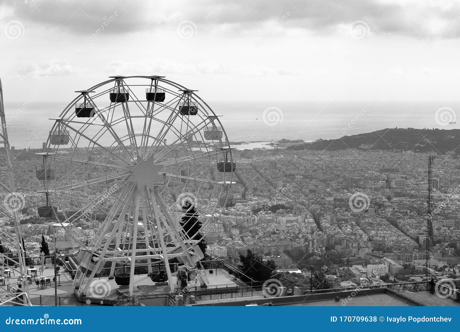 a graphical view of the ferris wheel of tibidabo amusement park with barcelona city at the back, barcelona, catalonia, spain